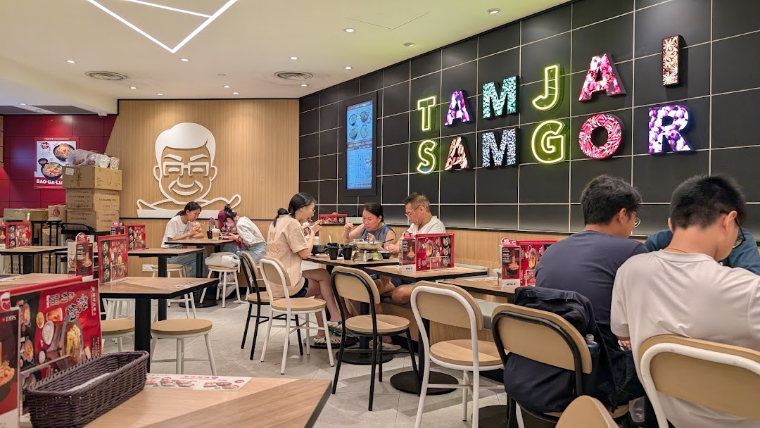 Diners enjoy meals in the vibrant, modern interior of TamJai SamGor Mixian restaurant.