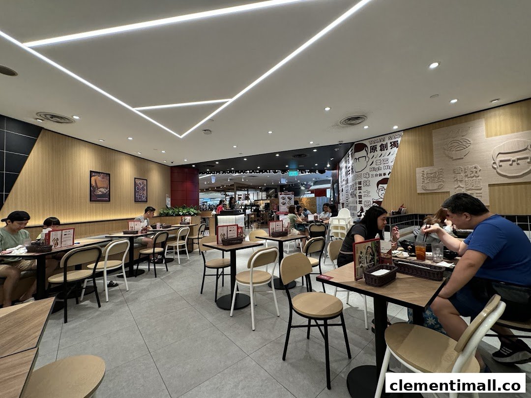 Diners enjoy a meal inside TamJai SamGor Mixian, featuring modern decor and comfortable seating.