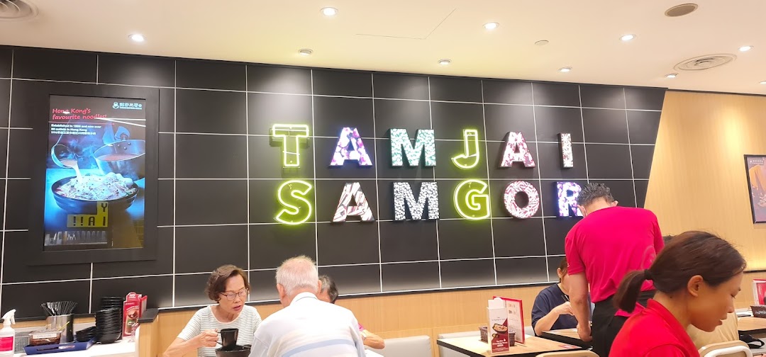 Customers dine inside TamJai SamGor Mixian, featuring the vibrant brand name on the wall.