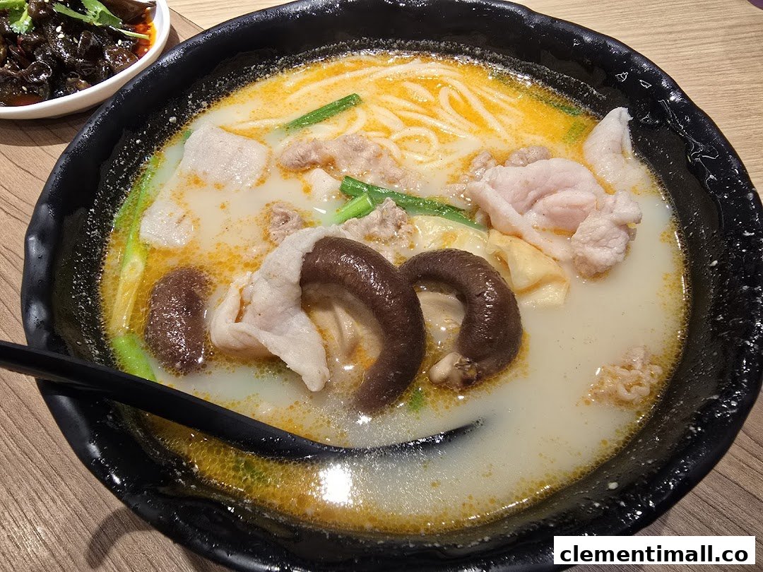A close-up of a delicious bowl of mixian noodles with pork, mushrooms, and a rich, flavorful broth.