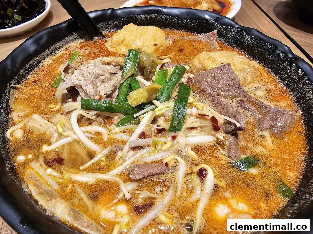 A close-up of a vibrant bowl of spicy mixian noodles with various toppings, including meat and vegetables.