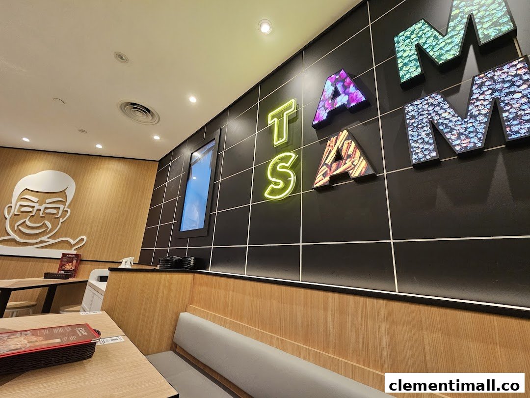 A vibrant interior shot of TamJai SamGor Mixian, featuring modern decor, comfortable seating, and illuminated wall art.
