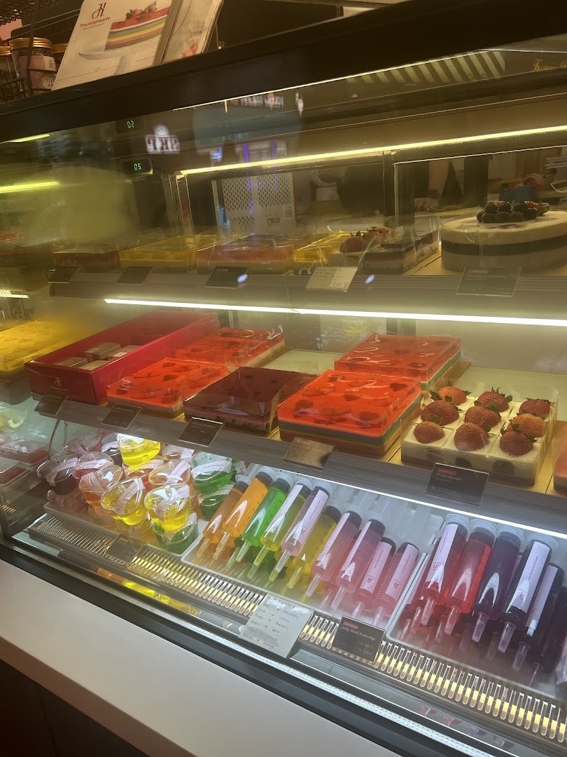 A vibrant display case showcasing colorful jelly desserts, cakes, and unique jelly syringe treats.