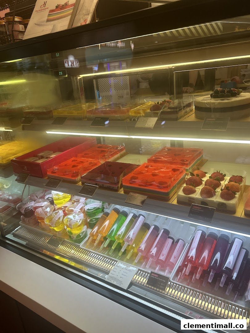 A vibrant display case showcasing colorful jelly desserts, cakes, and unique jelly syringe treats.