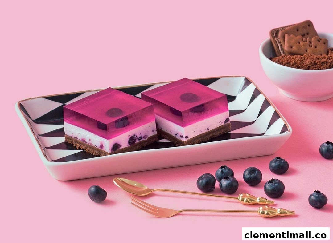Two vibrant pink jelly desserts with blueberry and cream layers on a decorative plate.