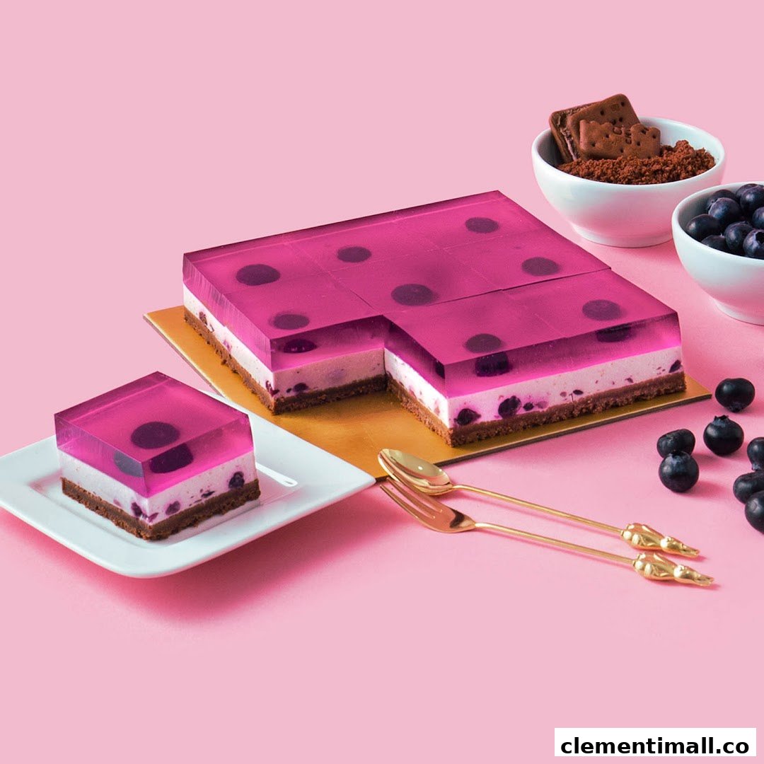 A vibrant blueberry jelly cheesecake with a slice served on a plate, set against a pink background.