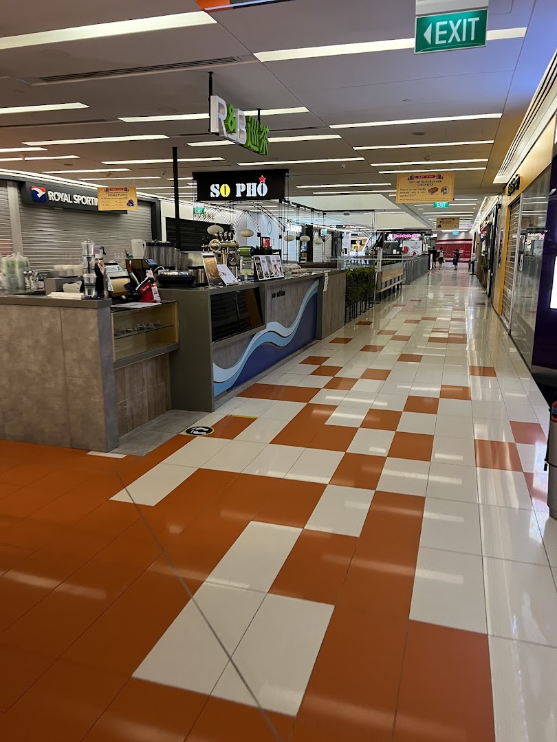 A wide view of a mall corridor featuring various retail and food outlets like So Pho and R&B.