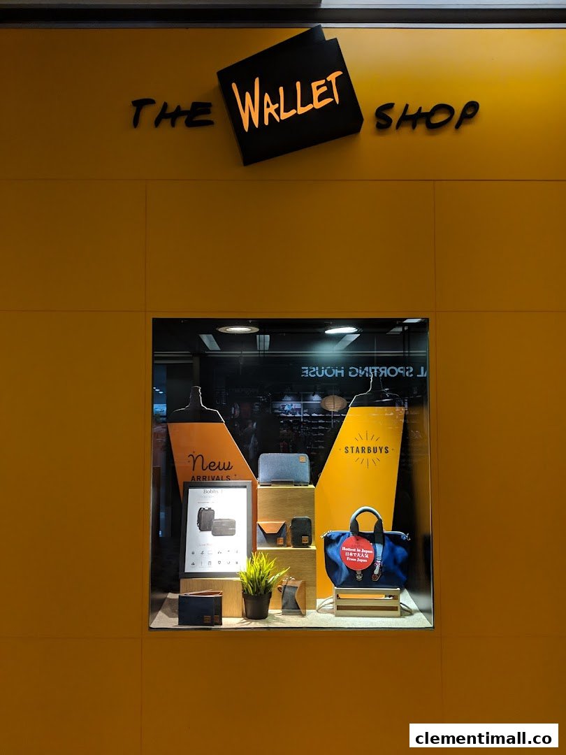 The vibrant yellow storefront of The Wallet Shop, showcasing a display window with wallets and bags.