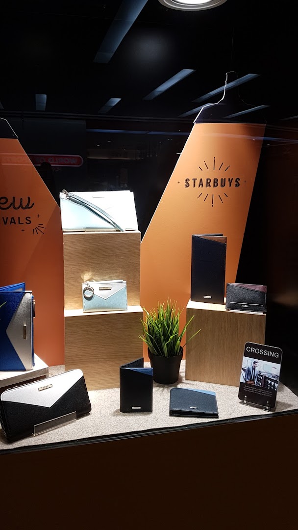 A well-lit display showcasing a variety of stylish wallets and small leather goods in a retail shop.