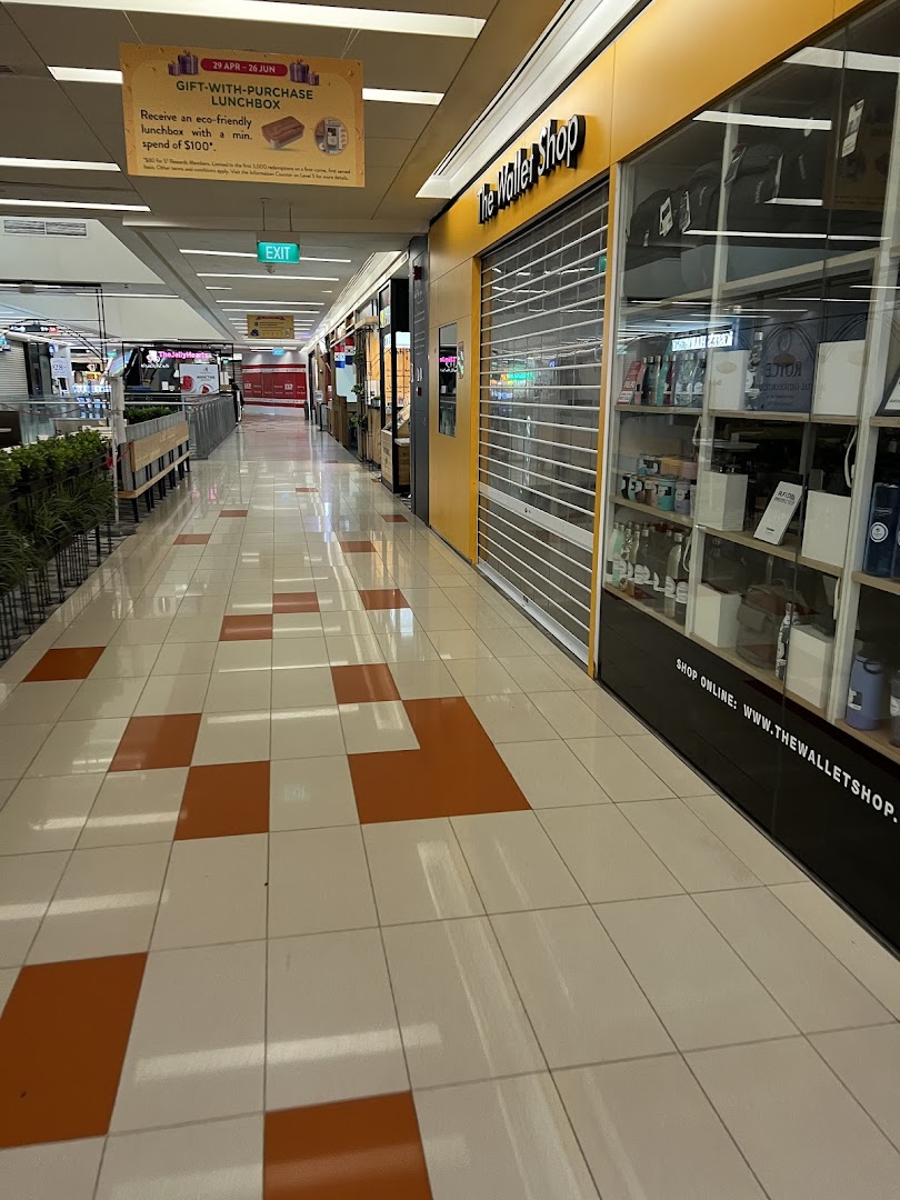 The Wallet Shop's storefront with a closed shutter, display windows, and mall corridor view.