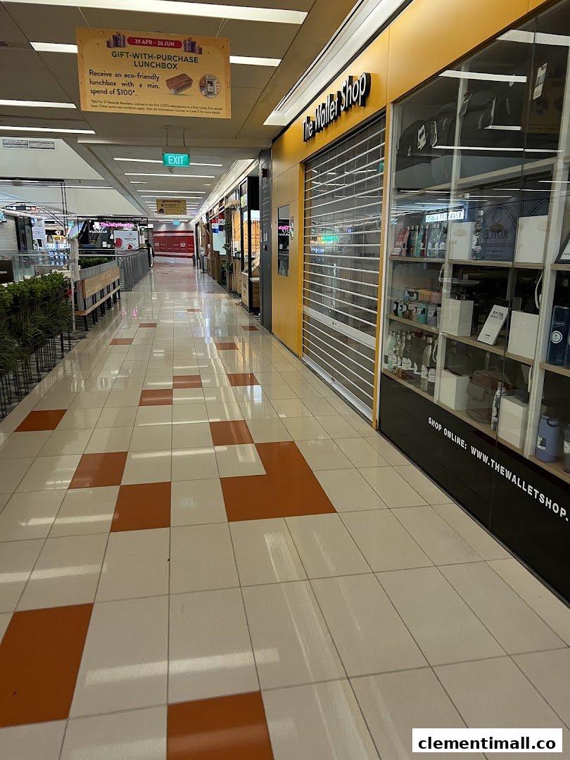 The Wallet Shop's storefront with a closed shutter, display windows, and mall corridor view.