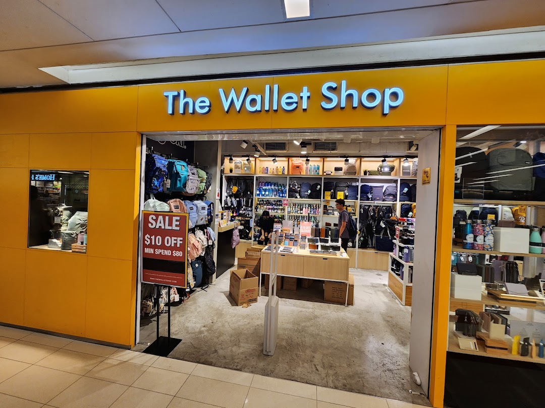 The storefront of The Wallet Shop, showcasing a wide array of wallets, bags, and accessories, with a sale sign.