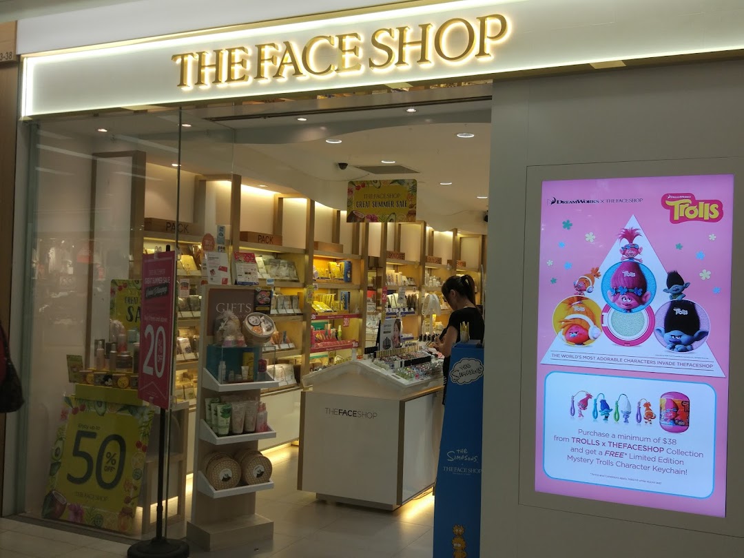 The exterior of THEFACESHOP, showcasing its entrance, logo, and vibrant beauty product displays.