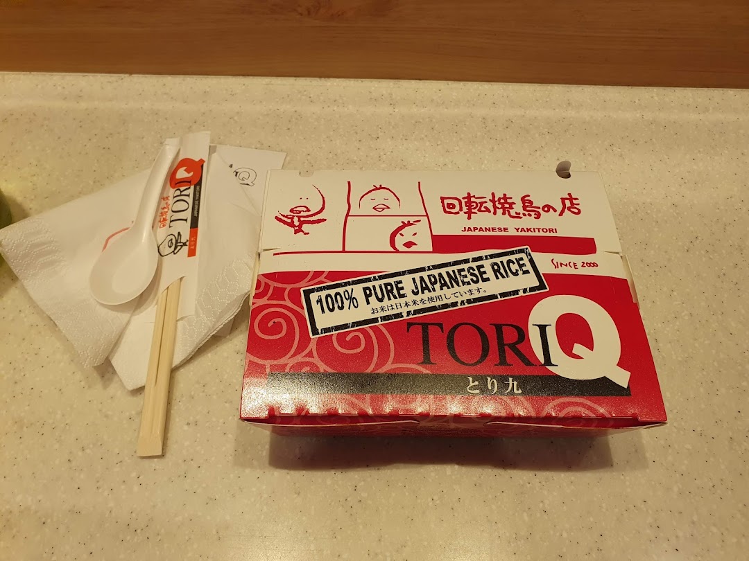 A TORI-Q take-out box featuring Japanese yakitori and 100% pure Japanese rice, with chopsticks and spoon.