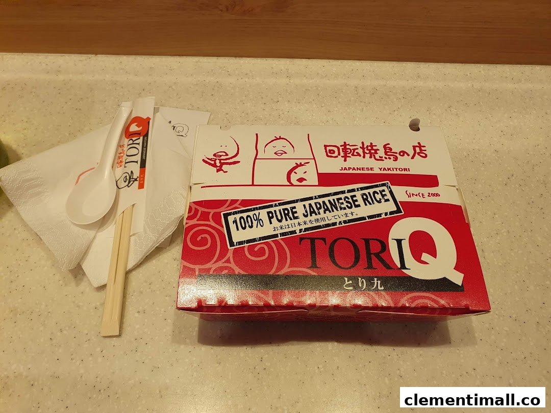 A TORI-Q take-out box featuring Japanese yakitori and 100% pure Japanese rice, with chopsticks and spoon.