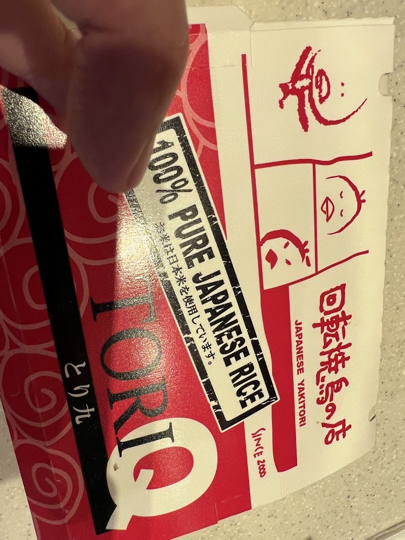 Close-up of TORI-Q food packaging, featuring Japanese text and '100% Pure Japanese Rice' label.