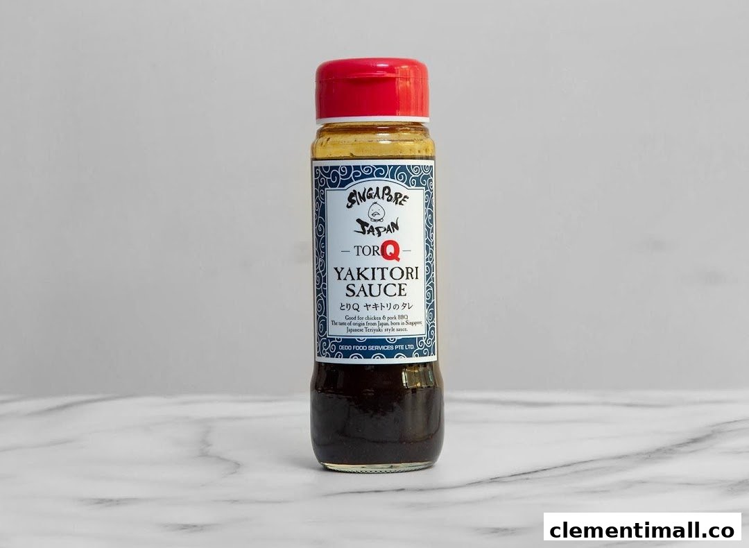 A bottle of TORI-Q Yakitori Sauce with a red cap on a marble surface.
