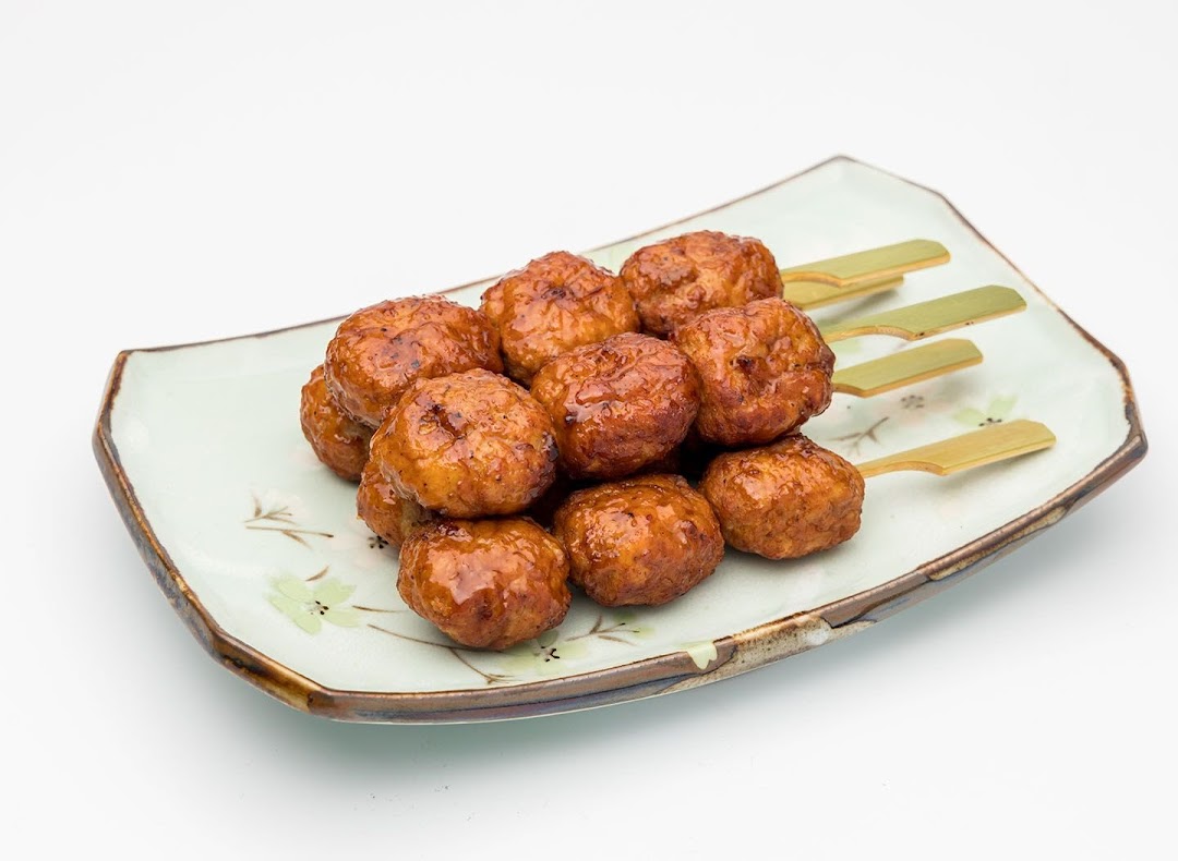 A plate of glazed chicken meatballs on skewers, ready to be enjoyed.