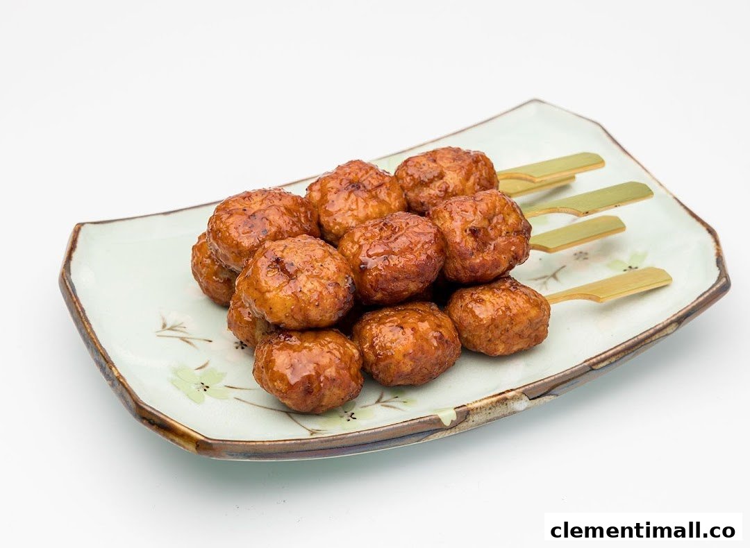 A plate of glazed chicken meatballs on skewers, ready to be enjoyed.