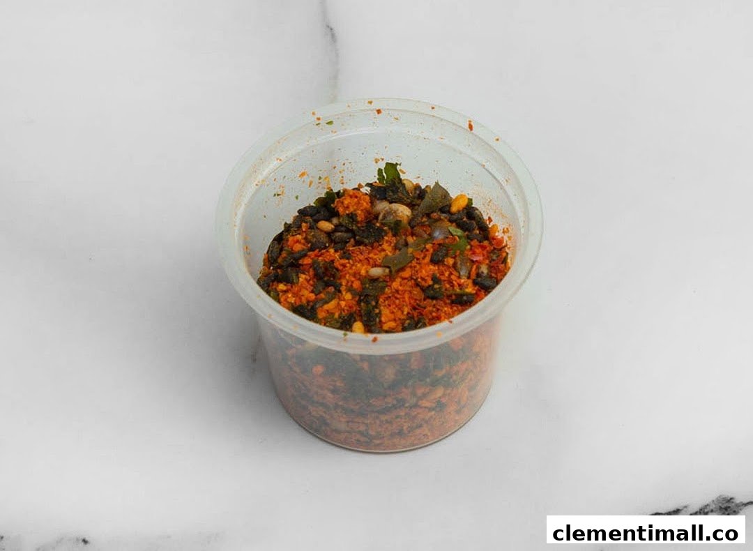 A clear plastic container filled with a vibrant mix of spices and dried ingredients.