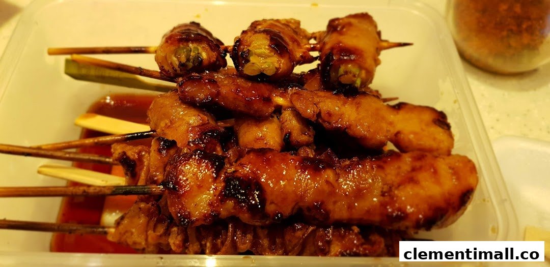 A clear plastic container filled with various grilled skewers, some with sauce, ready to eat.