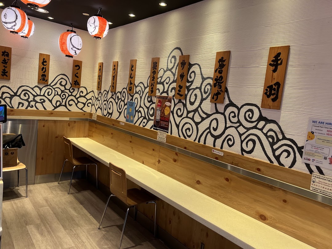 A cozy interior view of TORI-Q, featuring counter seating, Japanese lanterns, and traditional decor.