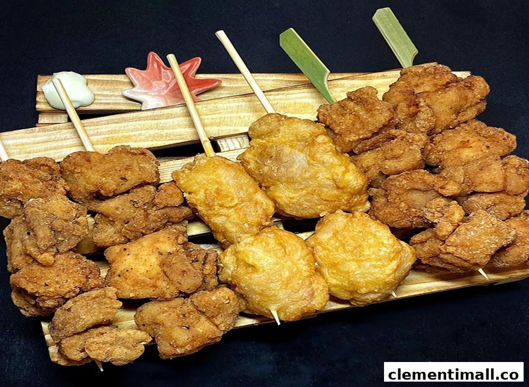 A wooden tray filled with various golden-brown fried chicken pieces and skewers, ready to eat.
