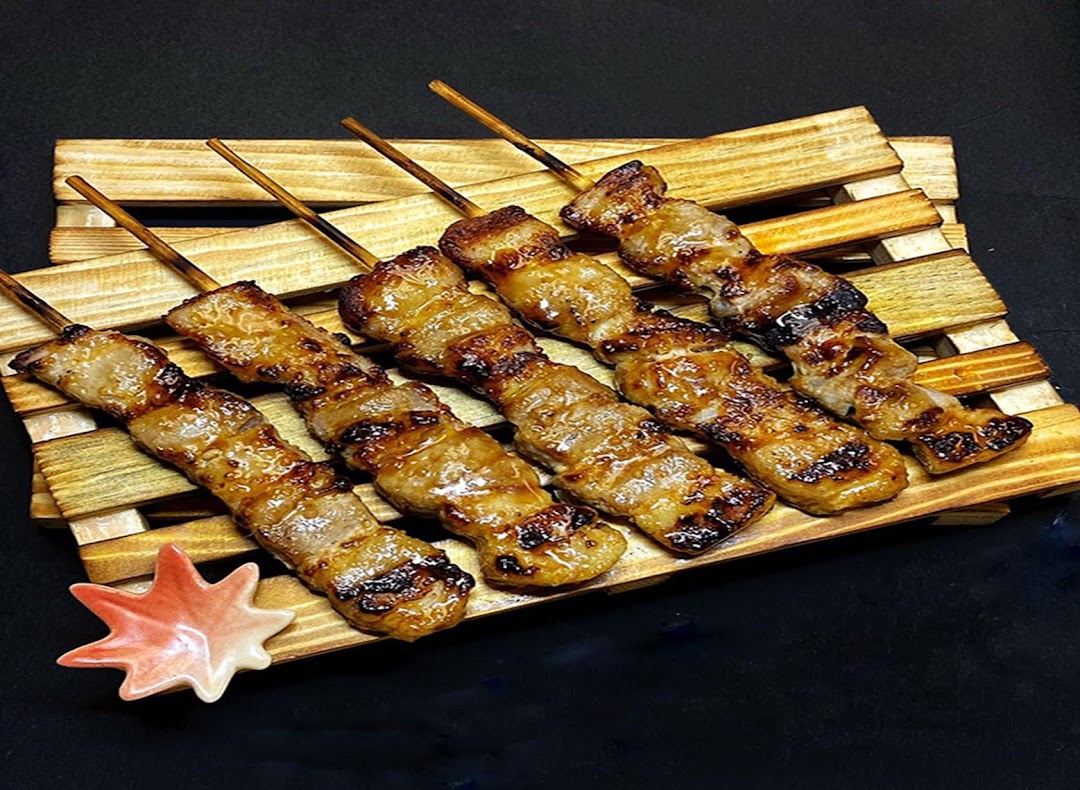 Delicious grilled meat skewers (yakitori) served on a rustic wooden tray.