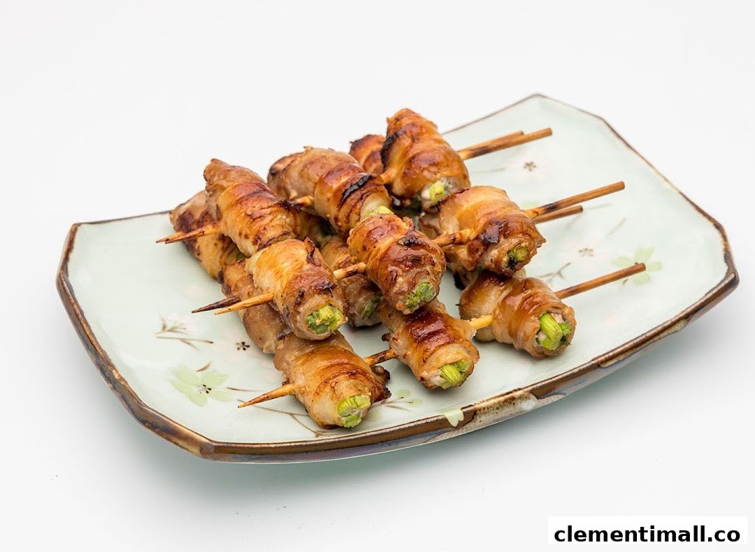 A plate of grilled skewers featuring meat-wrapped vegetables, likely yakitori, on a decorative dish.