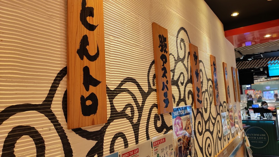 Interior view of TORI-Q's wall featuring decorative Japanese-style wooden signs and wave patterns.