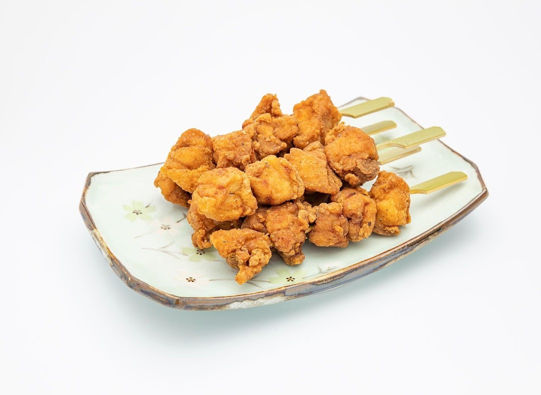 A plate of golden-brown fried chicken pieces on skewers, ready to be enjoyed.