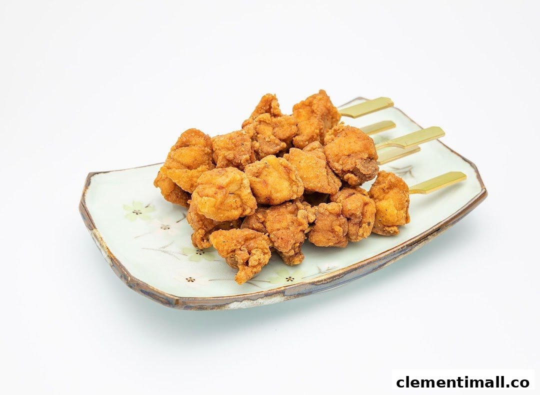 A plate of golden-brown fried chicken pieces on skewers, ready to be enjoyed.