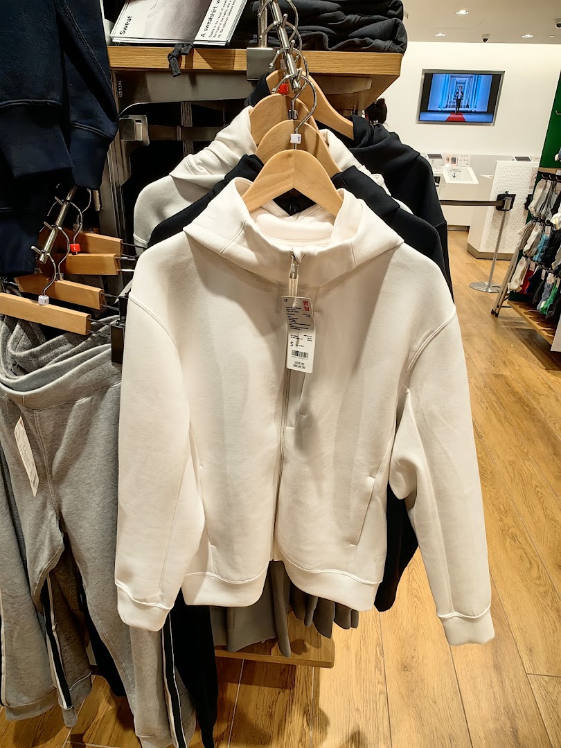 A rack of comfortable hoodies and sweatpants displayed inside a UNIQLO store.