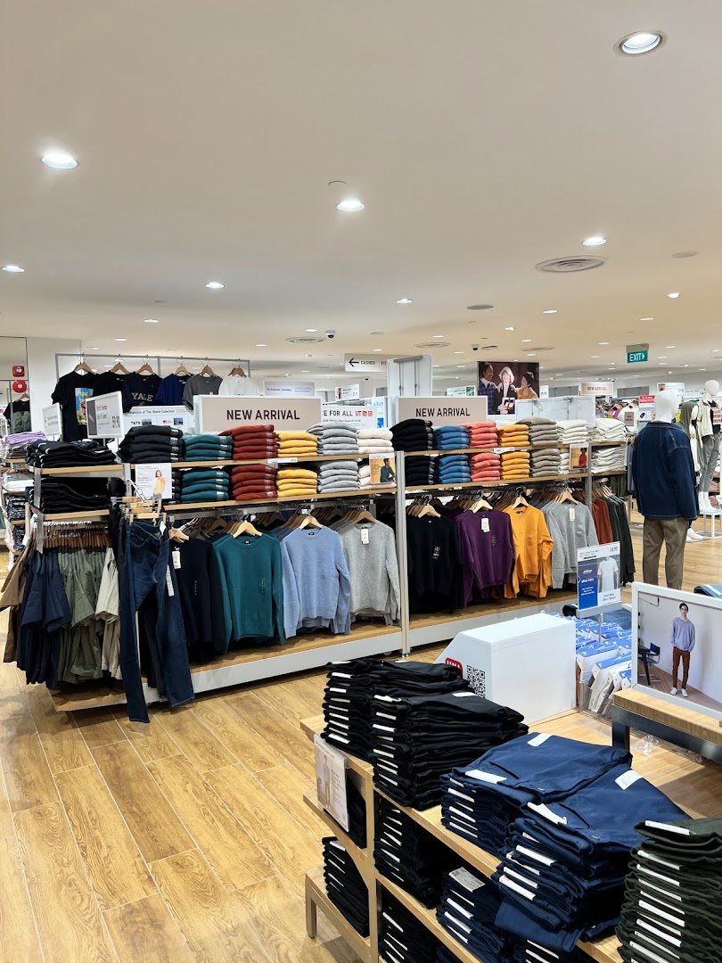 An interior view of UNIQLO, showcasing neatly folded and hung apparel, including new arrivals.