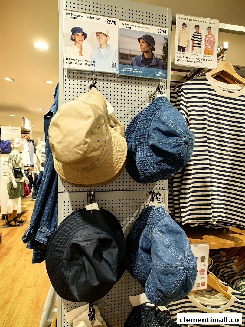 An in-store display at UNIQLO featuring UV protection hats and striped t-shirts.