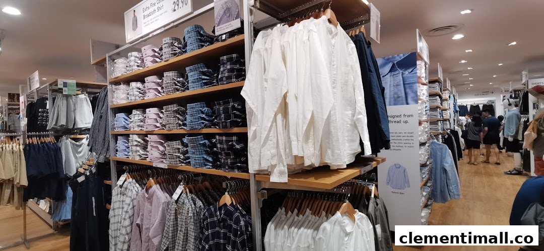 An interior view of UNIQLO, showcasing neatly displayed shelves of shirts and various apparel.