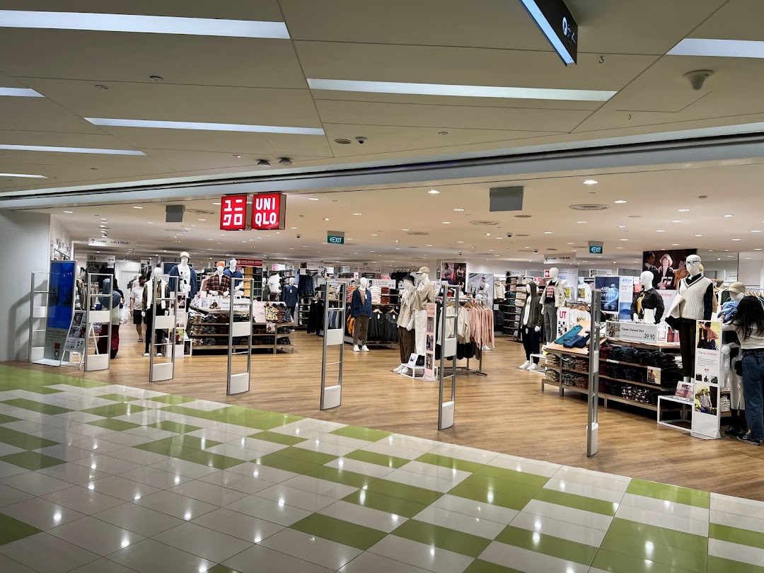 The inviting entrance of a UNIQLO store, showcasing various clothing displays and mannequins.