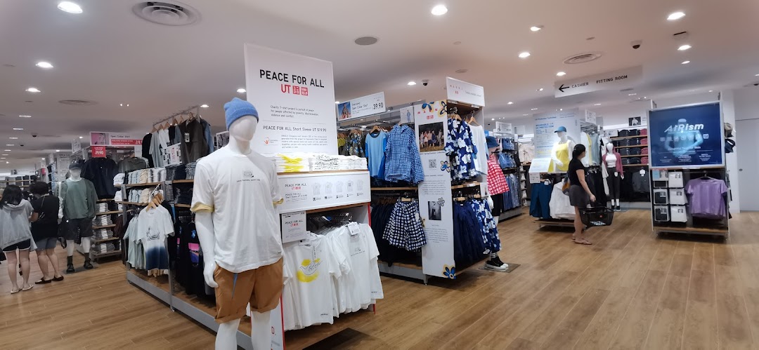 Interior view of a UNIQLO store showcasing various clothing collections, mannequins, and customers.