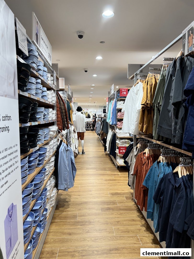 An interior view of UNIQLO, showcasing aisles of neatly displayed clothing and a wide selection.