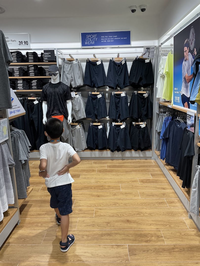 A child explores the sportswear section of UNIQLO, featuring utility wear and active apparel.