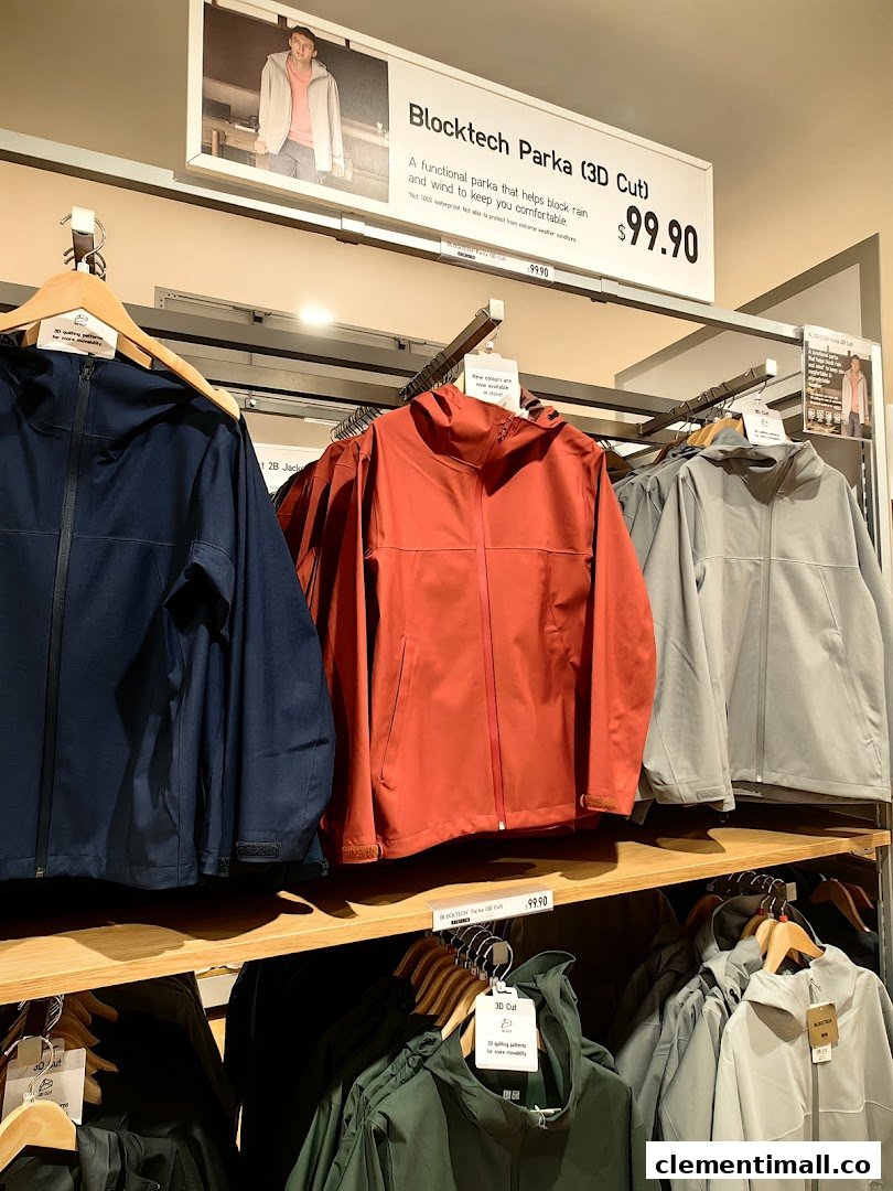 UNIQLO's Blocktech Parkas on display with a promotional sign detailing features and price.