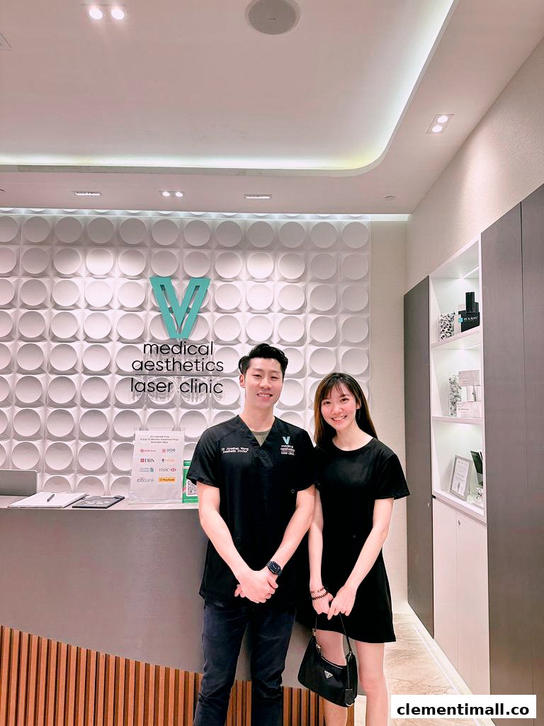 Two staff members smiling at the reception desk of V Medical Aesthetics & Laser Clinic.