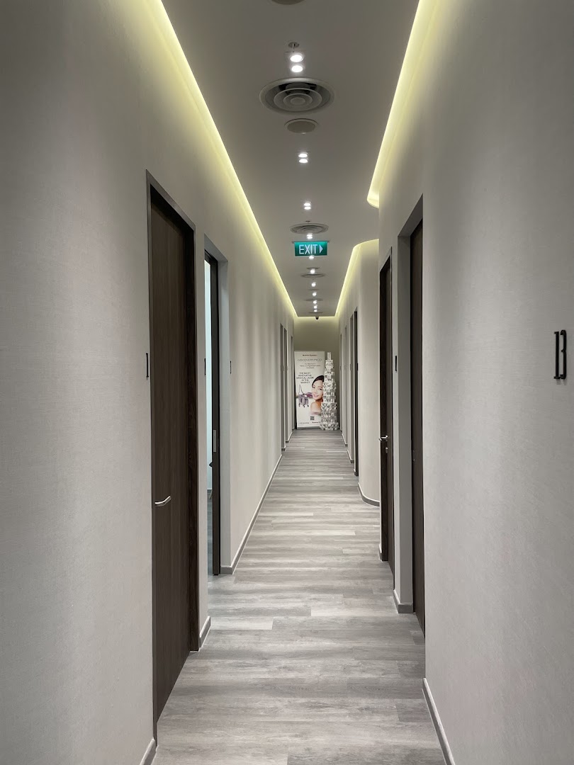 A modern, well-lit hallway with multiple treatment room doors inside the clinic.