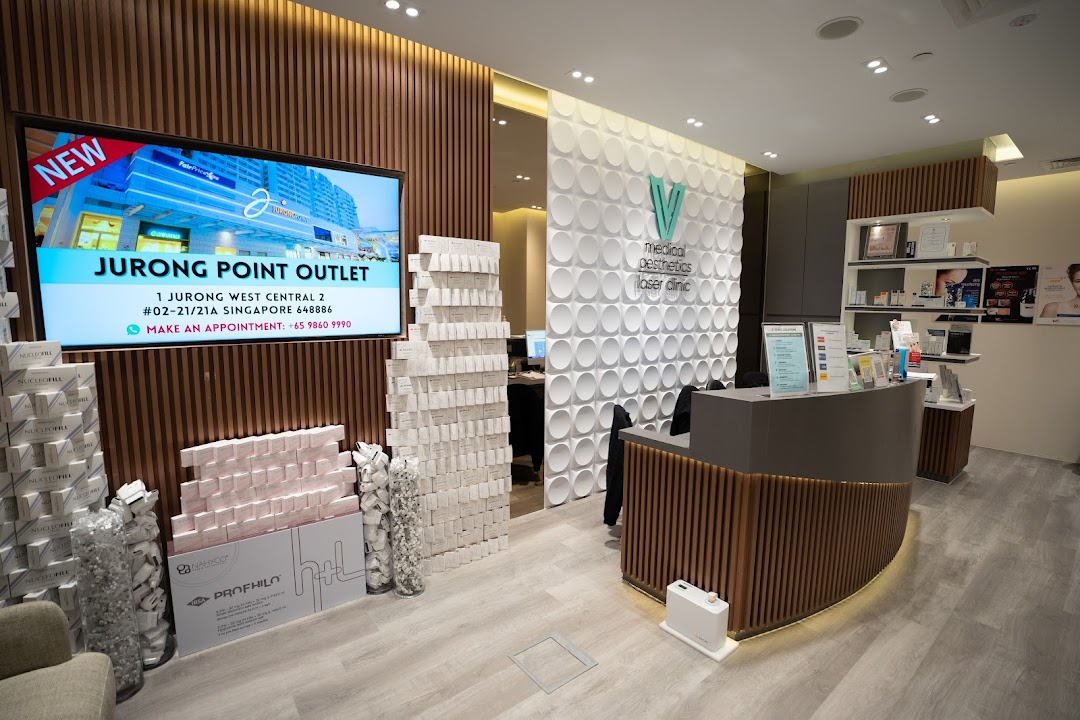 Interior view of V Medical Aesthetics Laser Clinic, featuring the reception desk, product displays, and a digital screen.