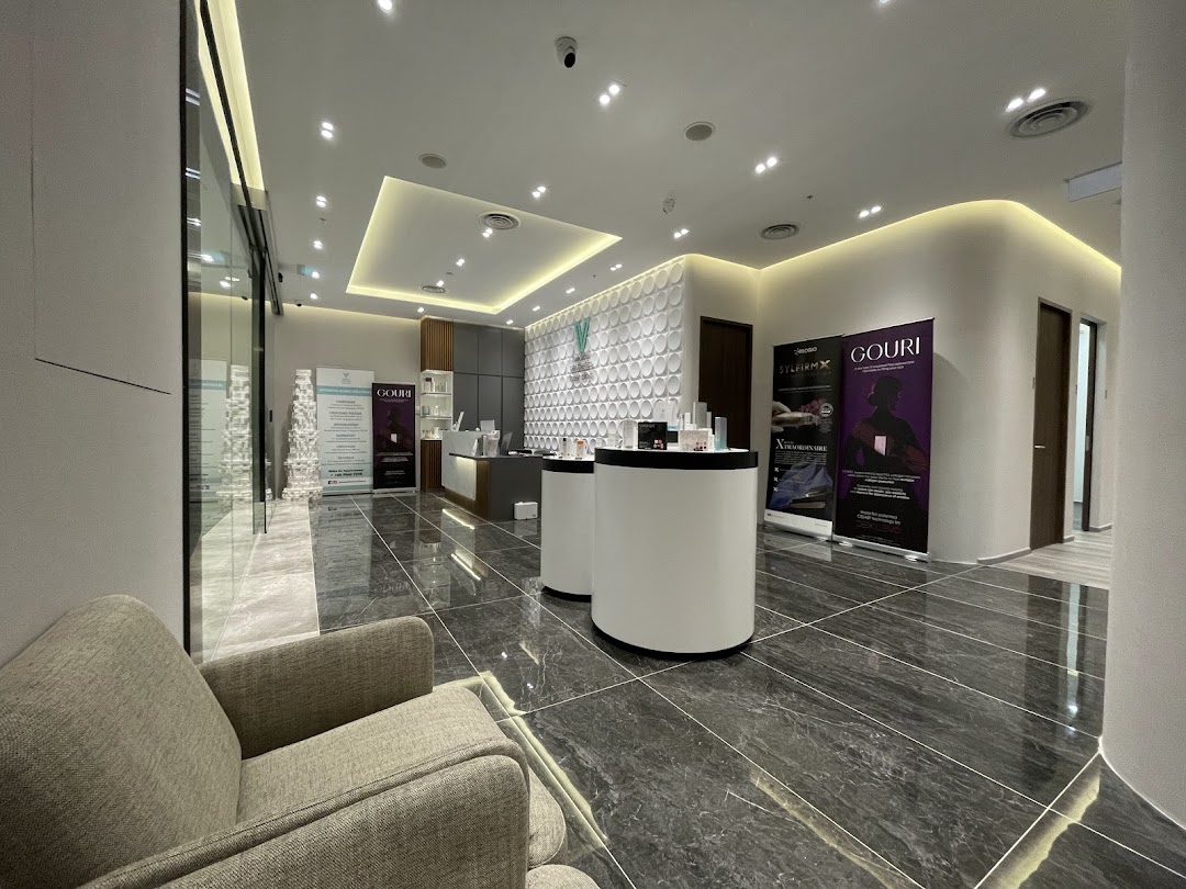 A modern, well-lit interior of V Medical Aesthetics & Laser Clinic, featuring a reception area and seating.