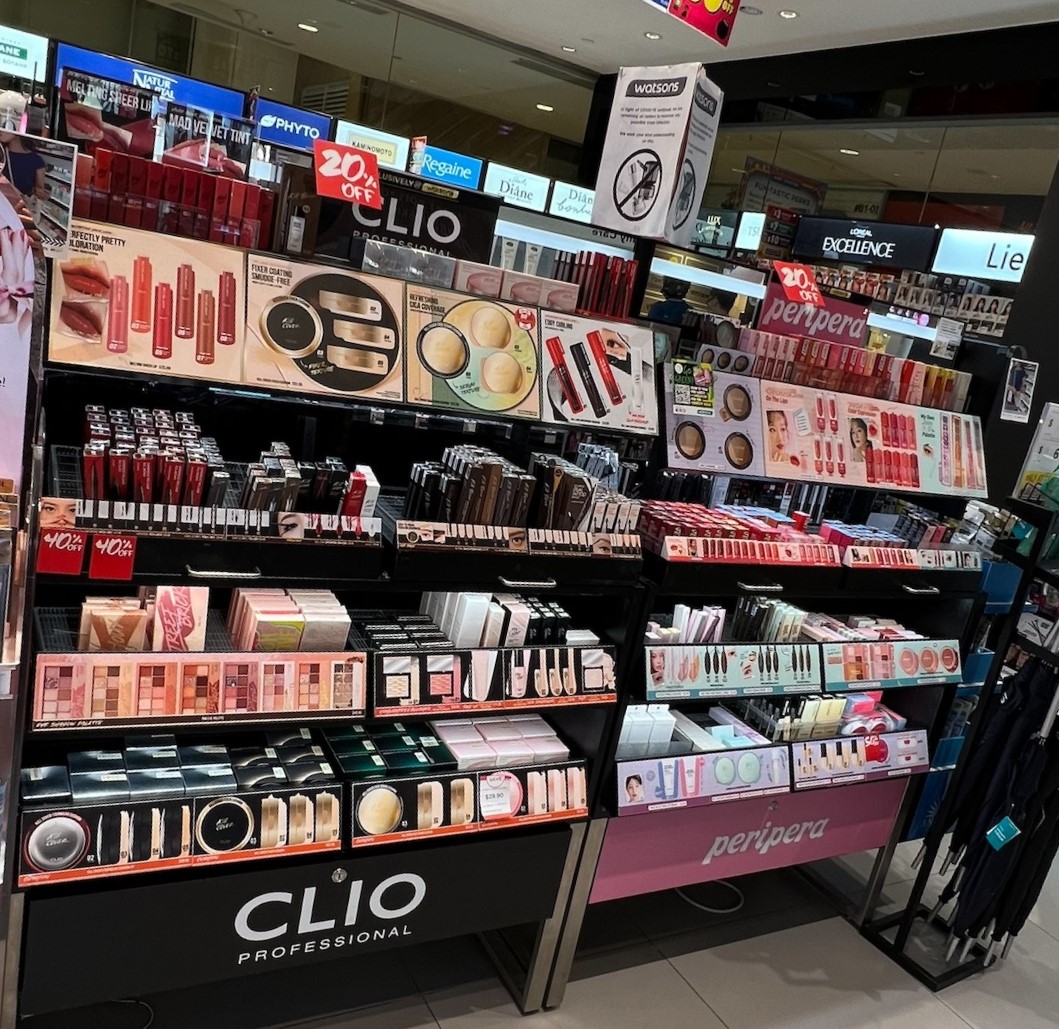 A vibrant display of cosmetics and beauty products from brands like Clio and Peripera inside Watsons.