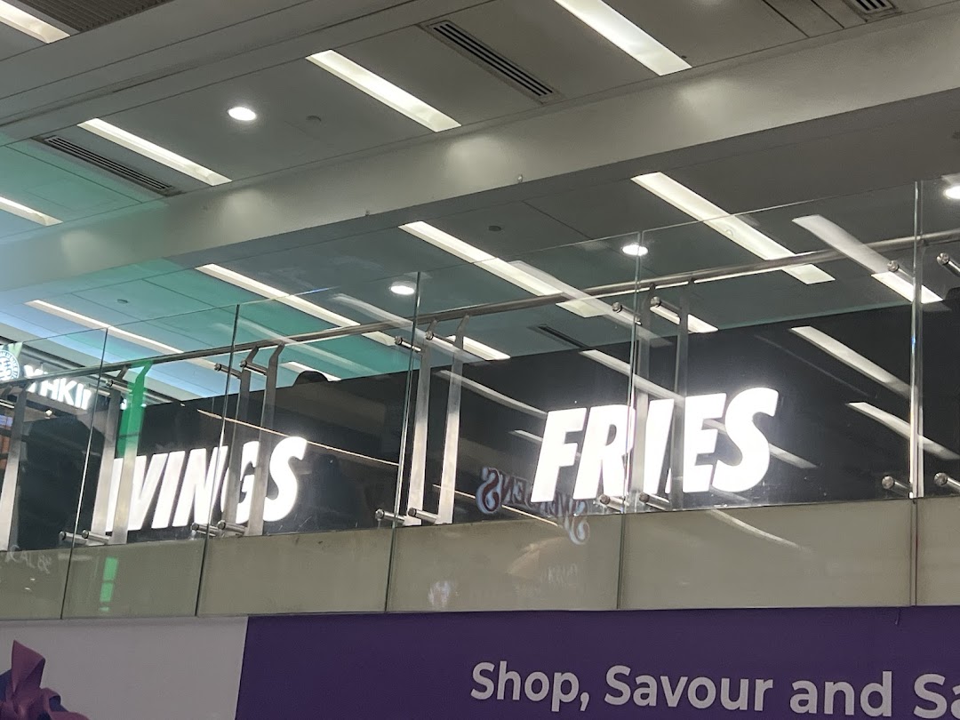 Bright signage for 'WINGS' and 'FRIES' visible from a distance within the mall.