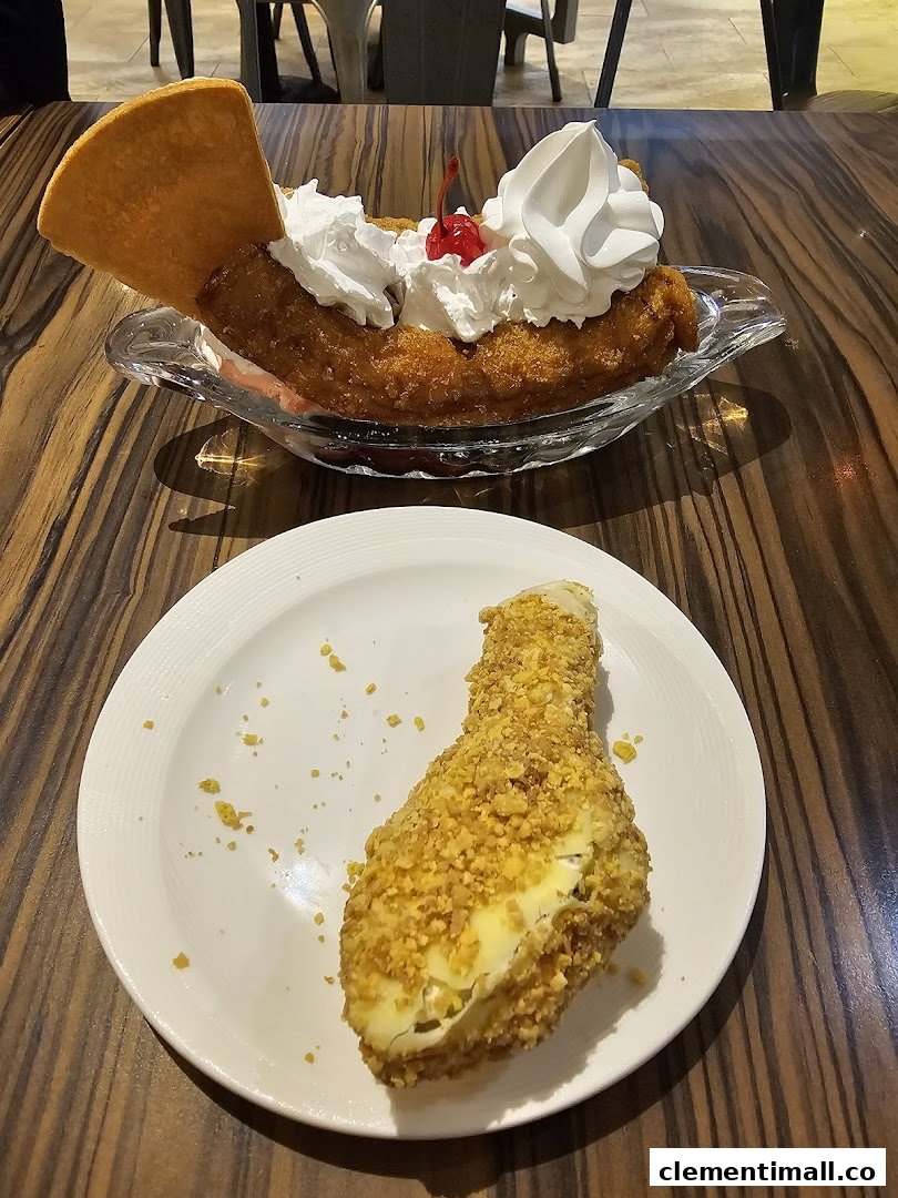 Delicious fried desserts, including a banana split, served on a wooden table.