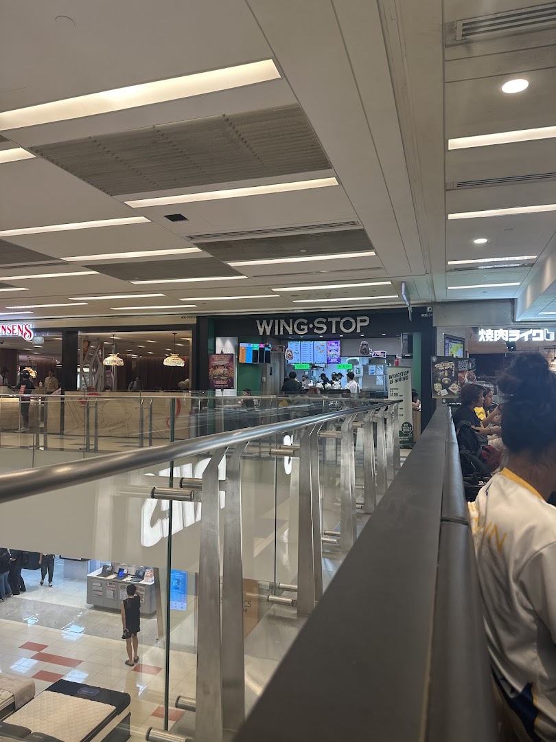 The Wingstop shop front is visible from an upper floor in a bustling shopping mall.