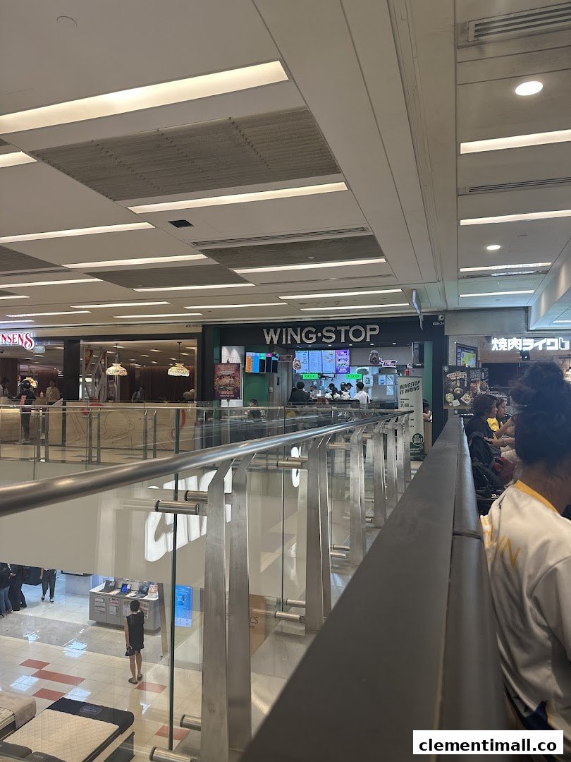 The Wingstop shop front is visible from an upper floor in a bustling shopping mall.